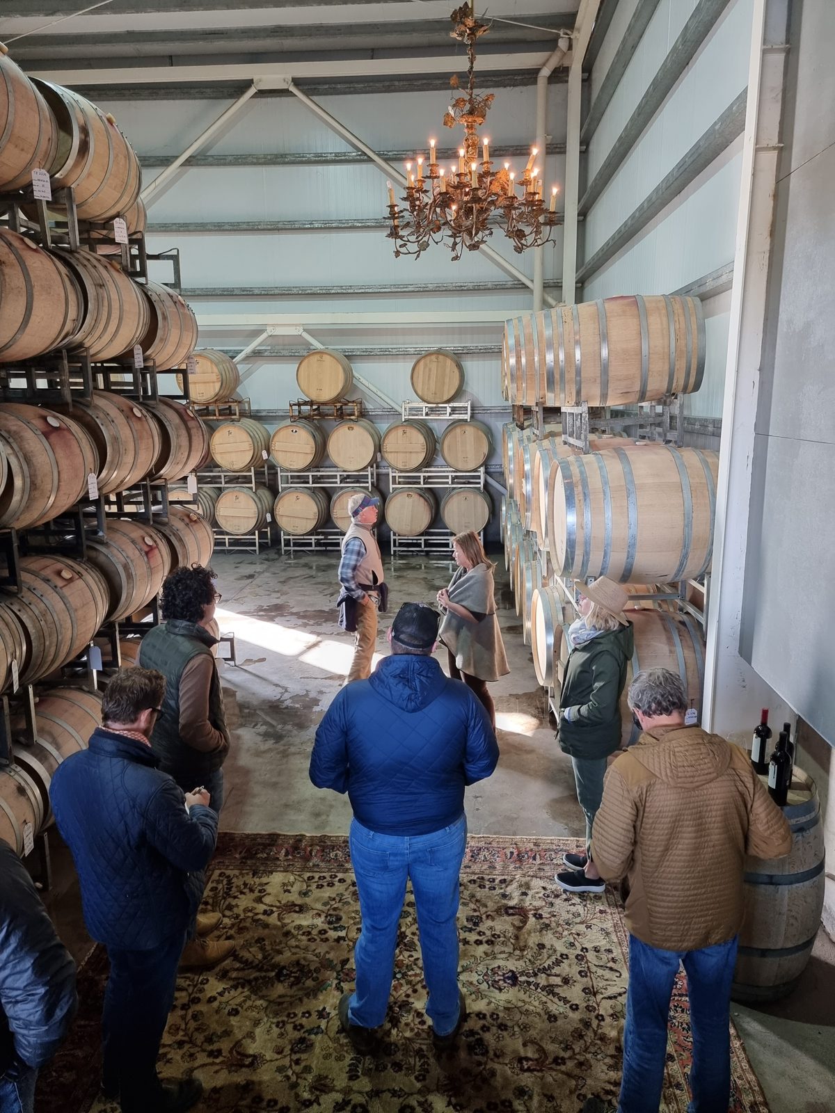 Walking the Tapiz barrel hall under its chandelier, French oak barrels stacked on both sides